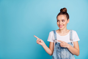 Canvas Print - Portrait of cheerful lady looking at copy space wearing white t-shirt denim jeans isolated over blue background