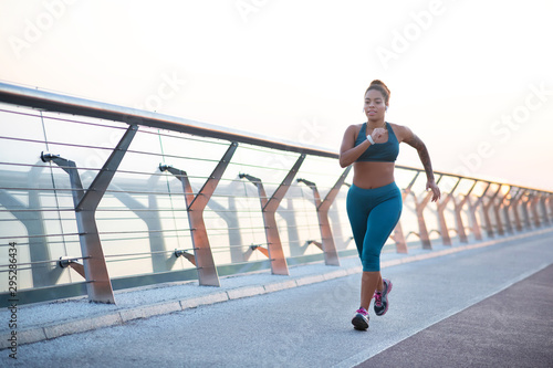 Fotografía Dark-skinned young overweight woman running really fast