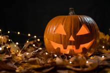 Halloween Carving Pumpkin On A Leafs. Shining Jack-o'-lantern.