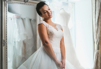 Wall Mural - Beautifu bride choosing wedding dress in a wedding salon