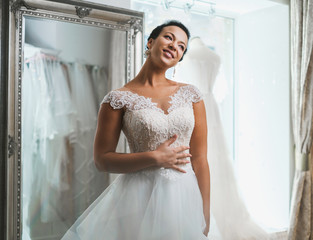 Wall Mural - Beautifu bride choosing wedding dress in a wedding salon