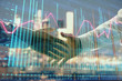 © Andrey - Double exposure of financial chart on cityscape background with two businessmen handshake. Concept of financial analysis and investment opportunities