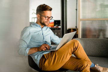 Young smiling Man typing on laptop