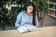 © Nejron Photo - Young woman reading book in public library