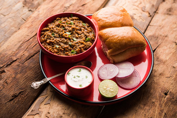 Wall Mural - Kheema / keema Pav or Khima Paav is a spicy curry dish made up of minced chicken or lamb cooked with onion, tomatoes, served with buns. selective focus