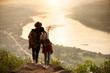 couple backpacker standing on cliff with sunset background