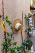 White and brown hat, drying on a line with wash pins against a wall of a hat store in a small street in France.