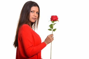 Wall Mural - Studio shot of young beautiful Brazilian woman holding red rose