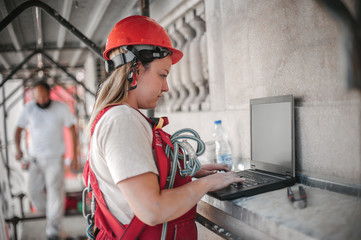 Female architect engineer inspects the construction site on laptop computer