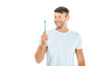 © LIGHTFIELD STUDIOS - cheerful man looking at toothbrush while smiling isolated on white