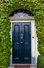 Georgian Style Vintage Blue Door House Surrounded By Green Ivy Leaves