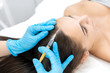© Kate - Close-up, the beautician makes injections of vitamins into the scalp for strengthening the hair.