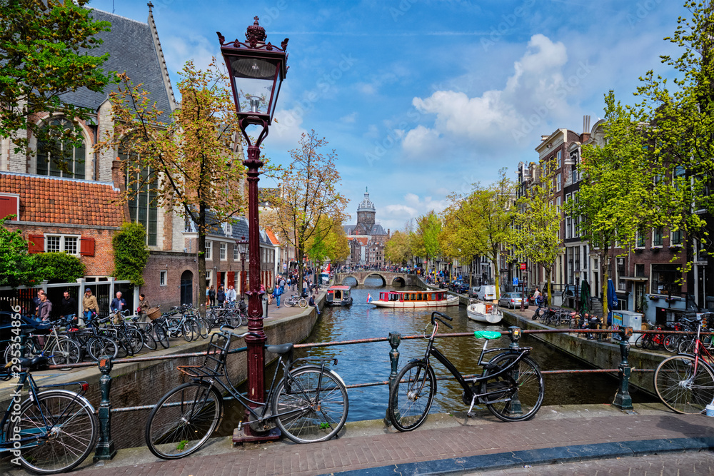 Obraz na płótnie Bicycles in Amsterdam street near canal with old houses w salonie