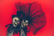 Bride And Groom Skull Wedding Dresses Symbol Of The Day Of The Dead And Hallowed, Typical American Party, With Red Background