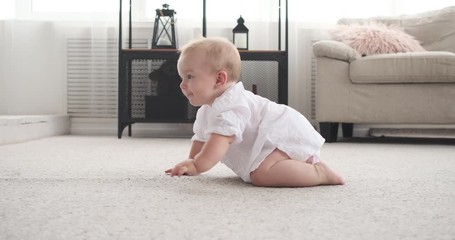 cute baby girl crawling on carpet at apartment