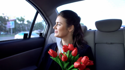 Wall Mural - Pretty lady sitting on backseat and holding tulips, successful date, happiness