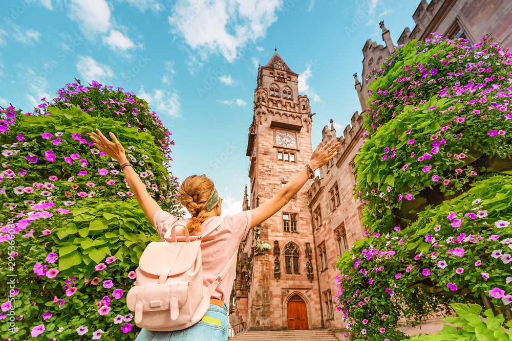 A girl traveler enjoys a view of the town hall building in Saarbrücken. Travel in Germany concept - obrazy, fototapety, plakaty 