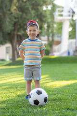 Wall Mural - little boy playing football soccer on the field