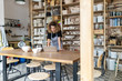 © pikselstock - Woman pottery artist using laptop in art studio
