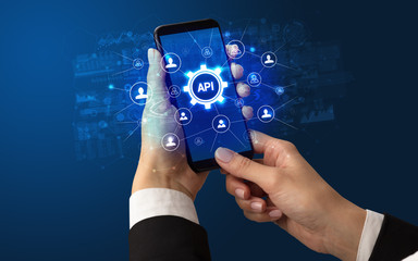 Poster - Female hand holding smartphone with API abbreviation, modern technology concept