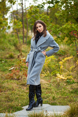 Poster - Portrait of young beautiful woman in gray coat posing in autumn park in Moscow