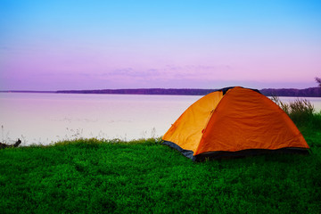 Wall Mural - tourist tent on shore of calm lake in early morning