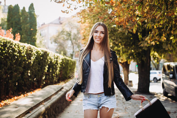 Wall Mural - A girl walking with bags after successful shopping on Black Friday