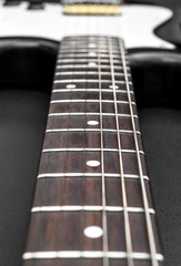 Wall Mural - Macrophoto of electric guitar on black background.