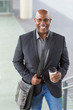 © digitalskillet1 - African American businessman drinking coffee on his way to work.