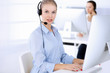 © Iryna - Call center office. Beautiful blonde woman using computer and headset for consulting clients online. Group of operators working as customer service occupation. Business people concept