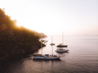 Wall Mural - Evening sunset on the mediterranean sea. Luxury yachts lined up along the Turkish coastline, islands can be seen in the distant background. Beautiful scene shot aerially from a drone.