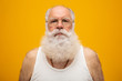 © Brastock Images - Old man with a long beard on a yellow background. Senior with full white beard. Old man with a long beard with sadness.