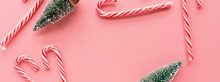 Top View Of Christmas Tree With Many Candy Canes On Pastel Pink Background. Banner For Web Design. Holiday Festive Celebration Copy Space For Text. Mockup, Template. Xmas Concept, Happy New Year 2020
