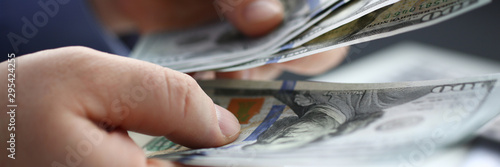 Fotomural Businessman considers cash dollars in office issues salaries to employees with black cash divides profits as result of illegal transactions everyone is happy