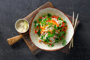 Thai noodles with vegetables on dark background top view