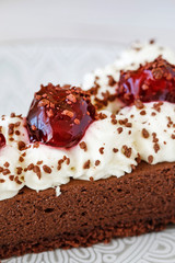 Poster - Chocolate cake with whipped cream decorated with cherries in a sweet sauce.