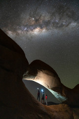 Wall Mural - group of people standing under milky way at rock arch spitzkoppe, namibia.