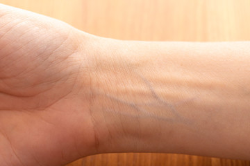 human wrist with blue veins visible through skin close up