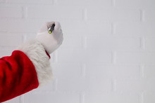 Santa Claus Writing With The Pen On The White Brick Wall
