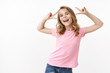 Charismatic happy lively blond energetic kid, joyful girl show peace and victory, smiling upbeat and carefree playing with parents, travel abroad children camp, having fun stand white background
