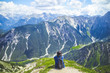 © sukanda - Woman traveller sitting admiring the scenery of the Alps mountains.