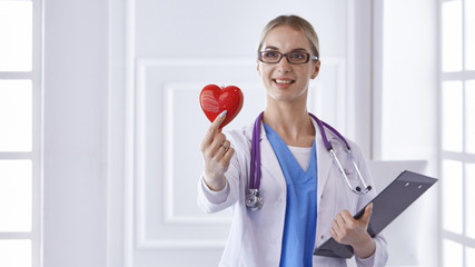 Doctor with stethoscope holding heart, isolated on white backgr