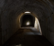 An Underground Corridor Extending Into The Distance, Lit Through A Hatch In The Ceiling.