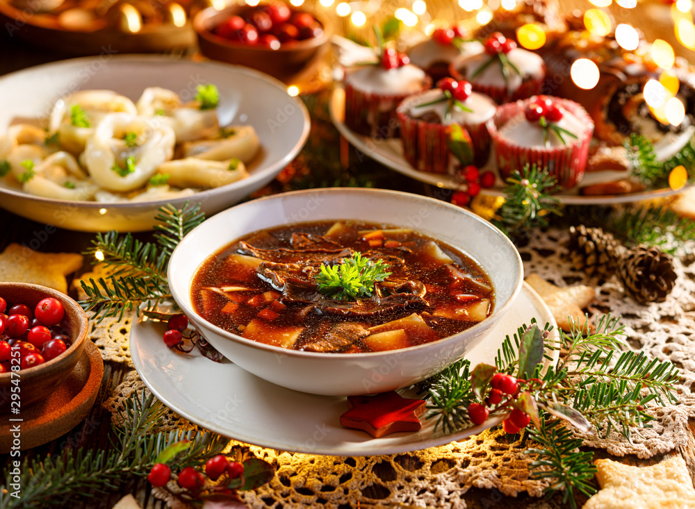 Christmas mushroom soup, a traditional vegetarian  mushroom soup made with dried forest mushrooms in a ceramik plate on a festive table. Polish Christmas dinner - obrazy, fototapety, plakaty 