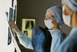 © lenetsnikolai - Two female women medical doctors looking at x-rays in a hospita