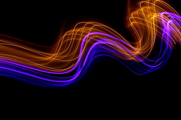 Wall Mural - Long exposure photograph of neon gold and purple colour in an abstract swirl, parallel lines pattern against a black background. Light painting photography.