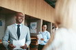 © Flamingo Images - Smiling African American businessman walking with colleagues in
