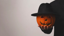 Jack O Lantern Holding His Pumpkin Head With Hat In Hand