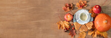 Autumn, Fall Leaves, A Hot Steaming Cup Of Coffee, Pumpkin And A Warm Sweater On A Wooden Table Background. Panoramic Image