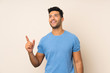 © luismolinero - Young handsome man over isolated background pointing up and surprised